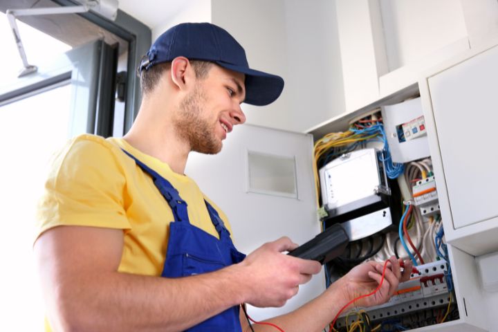 Electrician Measuring Voltage in Distribution Board